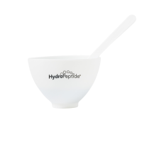 A white silicone bowl with a printed back Hydropeptide logo with a spatula sitting out the top on a white background